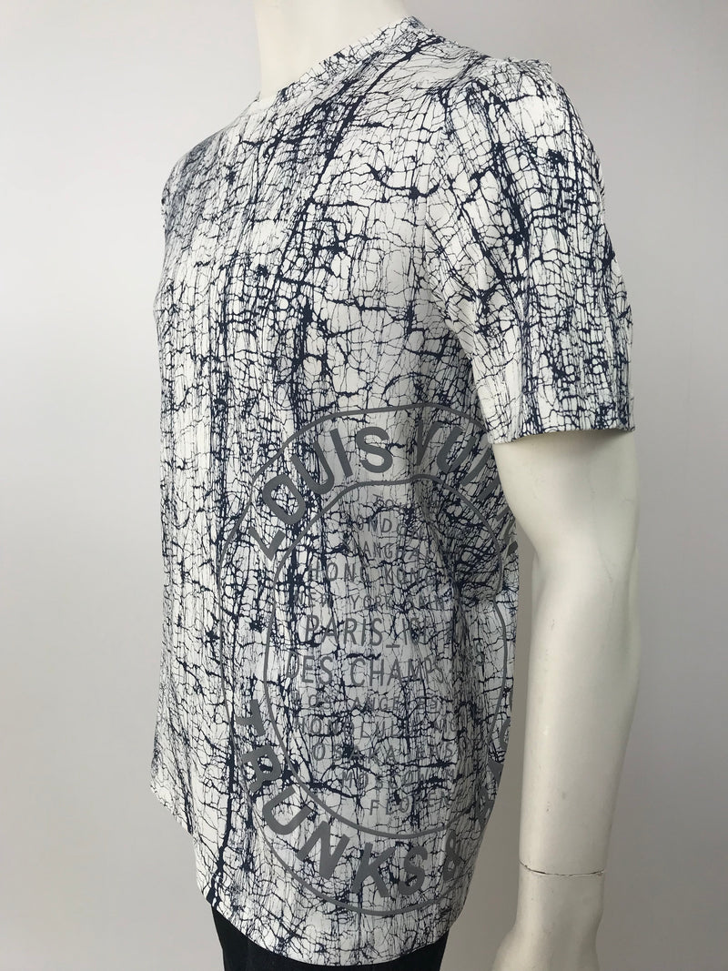 Luxuria & Co. - This luxurious cream colored Louis Vuitton t-shirt features  LV initials and the collection's show's details printed on the front along  with a rainbow pattern that wraps around the